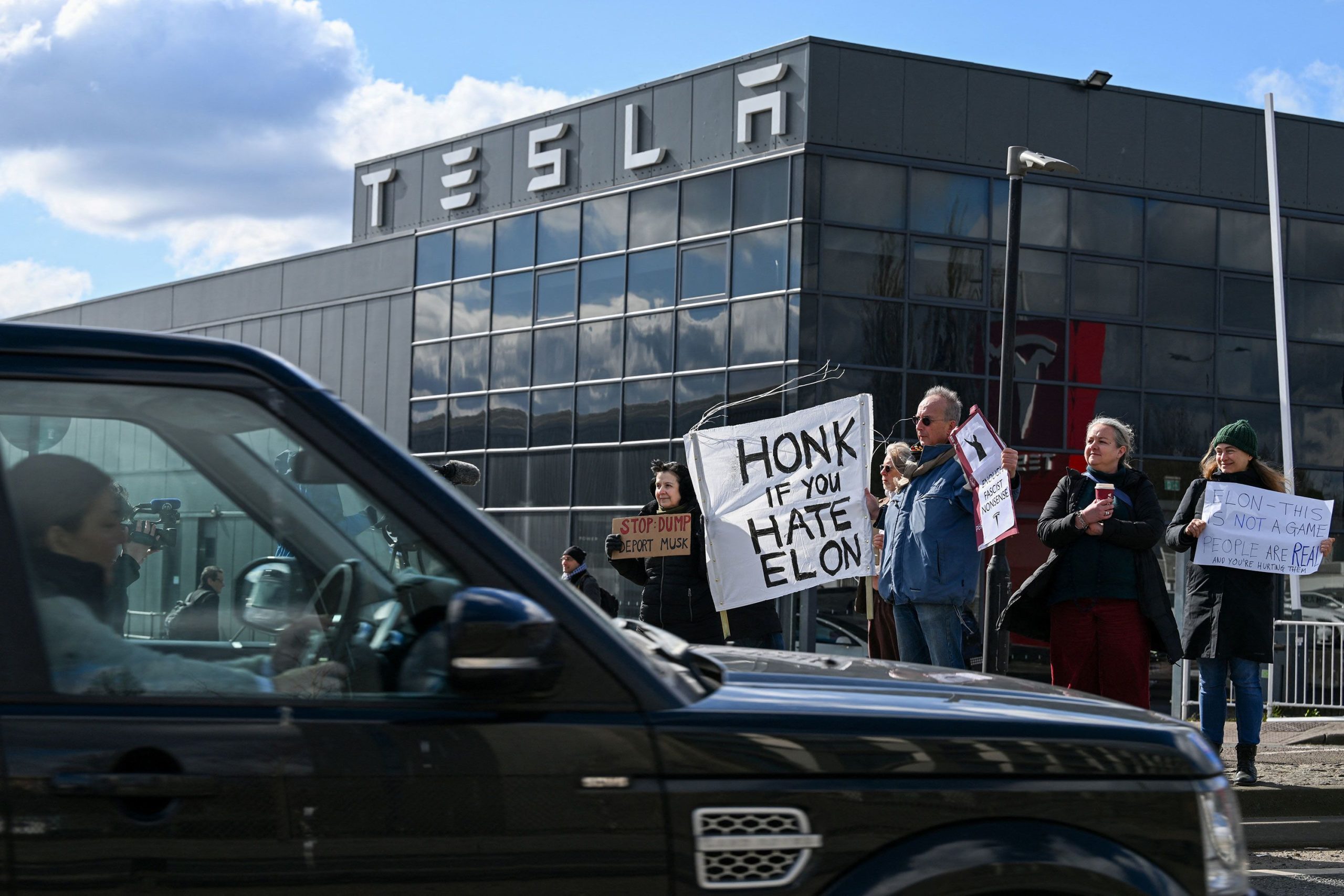Hundreds gather outside Tesla showrooms in backlash to Elon Musk’s role with DOGE